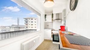 eine Küche mit einem Balkon und Stadtblick in der Unterkunft HOMEY PINKY - Proche Centre / Balcon privé / Wifi in Annemasse