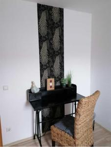 a black desk with a chair next to a wall at Ferienwohnung Mühlenbachhexe in Lingen