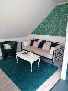 sala de estar con sofá y mesa en Ferienwohnung Mühlenbachhexe, en Lingen