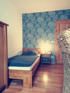 1 dormitorio con 1 cama y una pared con flores en Ferienwohnung Mühlenbachhexe, en Lingen