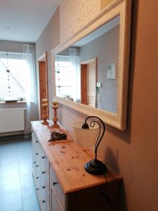 a bathroom with a vanity with a large mirror at Ferienwohnung Mühlenbachhexe in Lingen