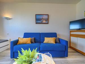un sofá azul en la sala de estar con TV en Studio Bleue Océane-2 by Interhome en Carnac