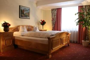 ein Schlafzimmer mit einem Holzbett und einem Fenster in der Unterkunft Schlossberghof Marzoll in Bad Reichenhall