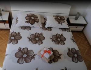 a bed with brown flowers on it with two pillows at Apartment Antea - private parking in Čilipi