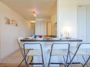 een keuken met een aanrecht met vier stoelen eromheen bij Apartment Les Bourdaines by Interhome in Seignosse