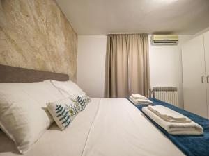 - une chambre avec un lit blanc et des serviettes dans l'établissement Apartment Beach Feelings by Interhome, à Sukošan