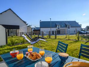 a blue table with a plate of food and glasses of orange juice at Apartment Les Villas du Men Du-3 by Interhome in Carnac