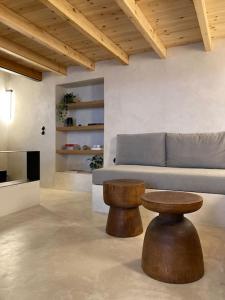 ein Wohnzimmer mit einem Sofa und einem Holzhocker in der Unterkunft Sommaripa Loft in Andros old town in Ándros