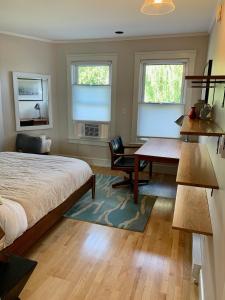a bedroom with a bed and a desk and two windows at 62 Views in Portland