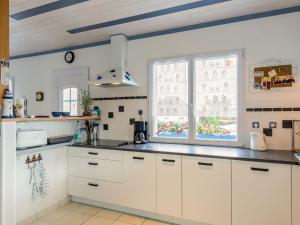 una cocina con armarios blancos y una ventana en Holiday Home La Glycine by Interhome, en Lampaul-Plouarzel