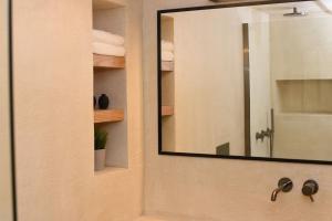 ein Badezimmer mit einem Spiegel und einem Waschbecken in der Unterkunft Sommaripa Loft in Andros old town in Ándros