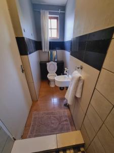 a small bathroom with a toilet and a sink at Houghton Skye in Johannesburg