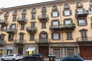 a large building with cars parked in front of it at [Loft in centro] Boutique 65 in Turin