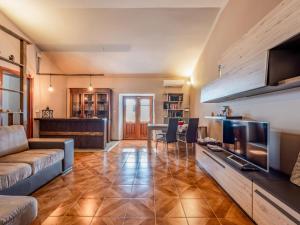 uma sala de estar com um sofá, uma mesa e uma televisão em Apartment Emilia Guest House by Interhome em Agliano Terme