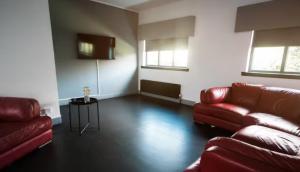 uma sala de estar com dois sofás vermelhos e uma mesa em Cunninghame 1 em Beith