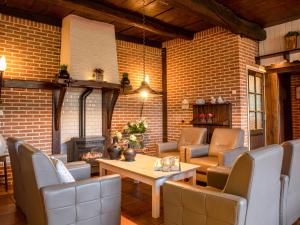 un soggiorno con tavolo, sedie e muro di mattoni di Holiday Home Familieboerderij by Interhome a Losser