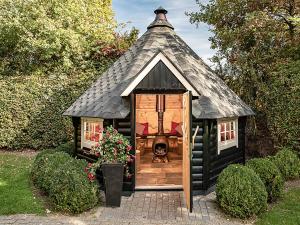 een klein speelhuisje met een rieten dak bij Holiday Home Familieboerderij by Interhome in Losser