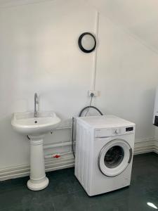 uma máquina de lavar roupa na casa de banho ao lado de um lavatório em Serenity apartments em Trou-aux-Biches