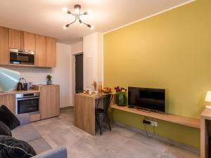 uma sala de estar com televisão e uma cozinha em Apartment Padova T2 by Interhome em Corte