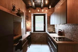 una cucina con armadi in legno e una finestra di Appartement thématique: Voyage Industriel a Travers