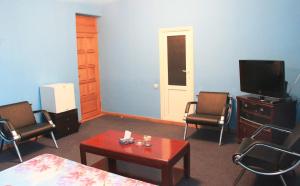 uma sala de estar com uma televisão e uma mesa e cadeiras em Argavand Hotel & Restaurant Complex em Argavand