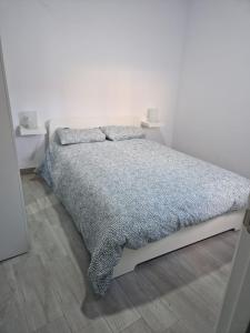 sypialnia z łóżkiem z szarą kołdrą w obiekcie Apartamento mi currilla w mieście Sanlúcar de Barrameda