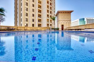 a large swimming pool in front of a building at Bright stylish sea view apartment in JBR in Dubai