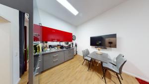 eine Küche mit roten Schränken sowie einem Tisch und Stühlen in der Unterkunft SweetHome - Luxus pur - große Küche, Stellplatz, WiFi in Magdeburg
