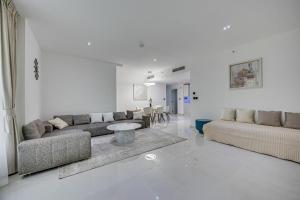 a living room with two couches and a table at Bright stylish sea view apartment in JBR in Dubai