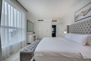 - une chambre avec un grand lit et une grande fenêtre dans l'établissement Bright stylish sea view apartment in JBR, à Dubaï