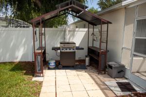 a barbecue grill under a pavilion in a backyard at Florida Escape in Orlando