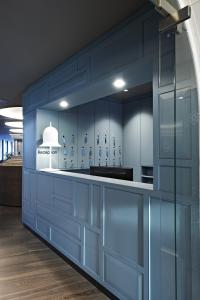 a kitchen with blue cabinets and a white counter at Badhaus - Hotel/Restaurant/Café in Bad Hall