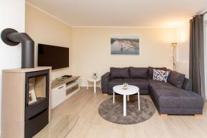 a living room with a couch and a tv at Hafendorf Haus 7_ Apartment 4 in Plau am See