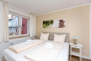 een slaapkamer met 2 bedden en een raam bij Hafendorf Haus 7_ Apartment 4 in Plau am See
