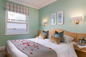 a bedroom with a bed with red roses on it at Hotel Penzance in Penzance