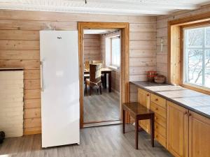 a kitchen with a white refrigerator and a table at Holiday home Austefjorden II in Austefjorden