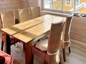 a wooden table with wicker chairs and a wooden table and chairsktop at Holiday home Austefjorden II in Austefjorden