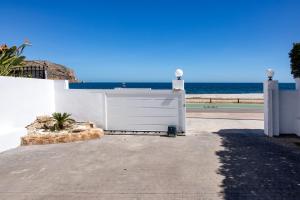 una puerta blanca con el océano en el fondo en San Luis, en Jávea