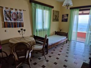a bedroom with a bed and a table and chairs at Atisis Apartments in Benitses