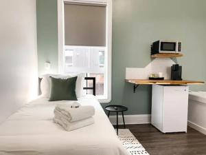 Un dormitorio con una cama blanca con toallas. en Sleeping Giant BNB en Thunder Bay