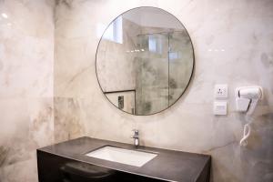 a bathroom with a sink and a mirror at Hillside Residence E-7 by Paramount Hospitality in Islamabad