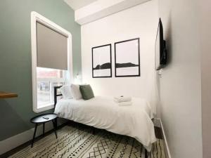 1 dormitorio blanco con 1 cama y 2 ventanas en Sleeping Giant BNB, en Thunder Bay
