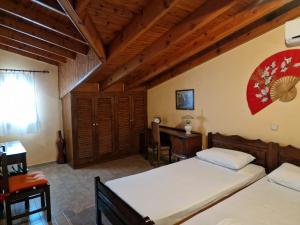 a bedroom with two beds and a desk in it at Atisis Apartments in Benitses