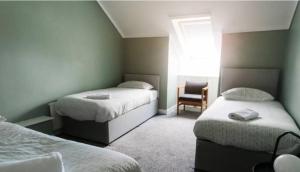 BeithにあるCunninghame 1のベッドルーム1室(ベッド2台、椅子、窓付)