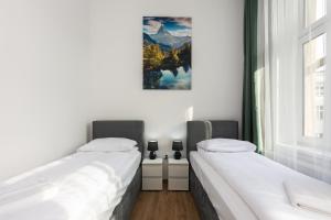 two beds in a room with a picture on the wall at Big flat for groups - for 13 pax, 100sq in Krakow