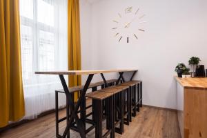 a table and stools in a room with a clock on the wall at Big flat for groups - for 13 pax, 100sq in Krakow