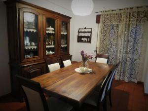 uma sala de jantar com uma mesa de madeira e cadeiras em Almadense em Almada