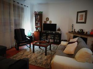 a living room with a couch and a tv at Almadense in Almada