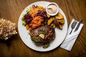 un plato de comida con carne y verduras en una mesa en Gościniec pod Zającem en Oleśnica