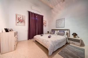 a bedroom with a bed and a dresser in it at Valletta 2 bedroom sleeps 6 apartment walking distance to centre and the sea in Valletta